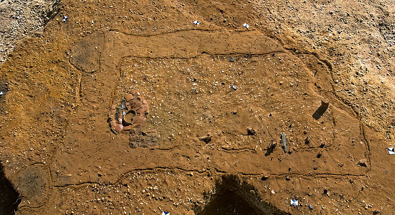 Grabgrube mit zerscherbter Keramik und durchlochter Steinaxt