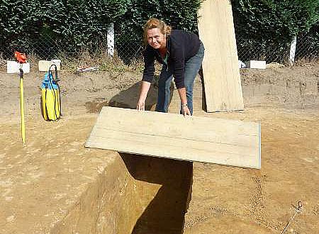 Ute Gröbe deckt eine Grube ab, damit niemand hineinstürzt. Am nächsten Tag wird dann daran weitergearbeitet. (Foto: LWL/Tremmel)