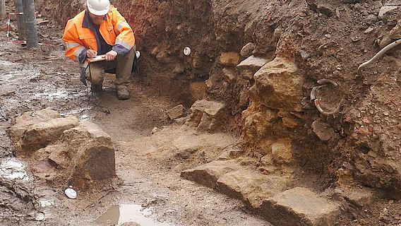Grabungsleiter Thies Evers legt eine Detailzeichnung der Mauerreste an