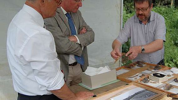 Mit großem Interesse lassen sich LWL-Direktor Dr. Kirsch (l.) und Ahlens Bürgermeister Ruhmöller (Mitte) von Grabungsleiter Dr. Grünewald die Funde von der Wallburg in Ahlen-Dolberg erläutern. (Foto: LWL/Burgemeister)