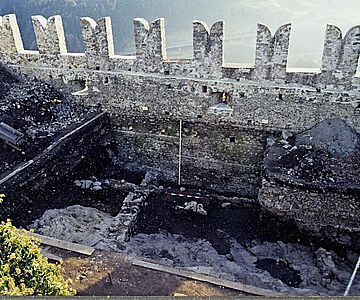 Blick von Norden auf die Grundmauern der spätantiken Eisenhütte, darüber die spätmittelalterliche Zinnenmauer