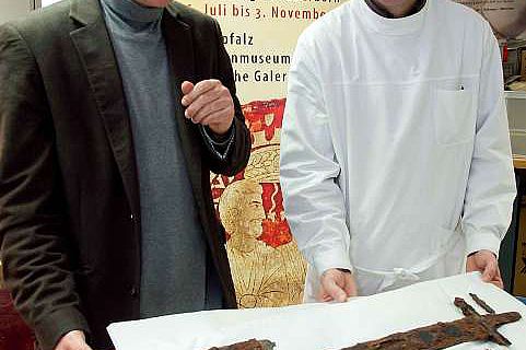 Dr. Martin Kroker und Andreas Weisgerber begutachten das Schwert des Fürsten. (Foto:LWL/Brentführer)