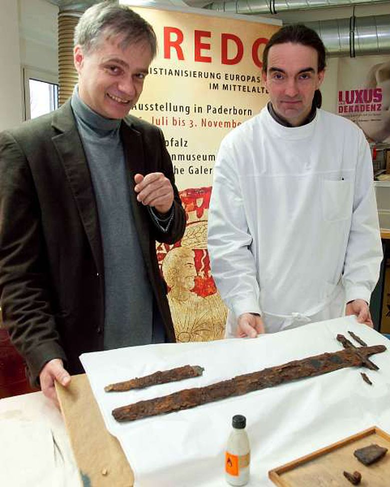 Dr. Martin Kroker und Andreas Weisgerber begutachten das Schwert des Fürsten. (Foto:LWL/Brentführer)