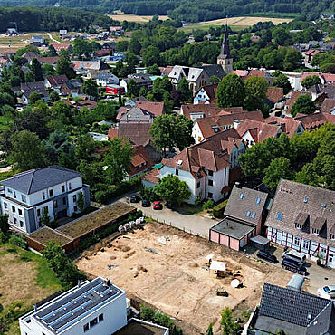 Grabungsfläche auf dem ehemaligen Gartengrundstück an der Ravensberger Straße. Im Bereich des heutigen Carports am linken Rand der Grabungsfläche konnten die Pfostenstellungen eines mittelalterlichen Wohngebäudes nachgewiesen werden, das man in der Nähe des Schwarzbaches errichtet hatte. (Foto: Archäologie am Hellweg e.G./H. Nabo)