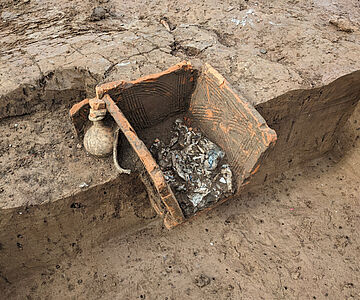 Ziegelplattengrab mit Leichenbrand und Henkelkrug