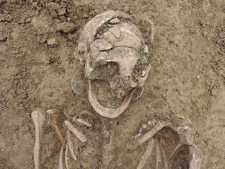 Detail des Schädels mit Ohrringen und Perlen des frühmittelalterlichen Frauengrabes
