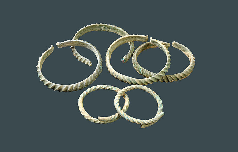 Das Ringdepot besteht aus zwei Armringen (Vordergrund) und vier Beinringen. Foto: Landesamt für Archäologie Sachsen