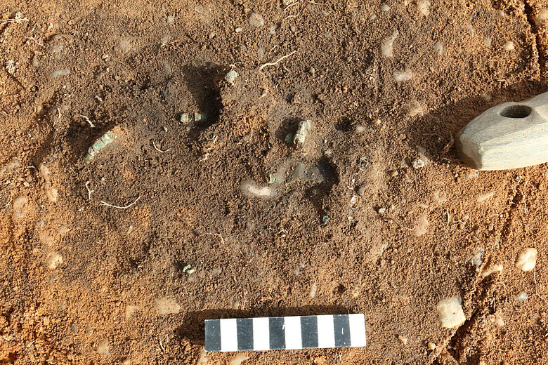 Steinaxt und Kupferperlen in situ