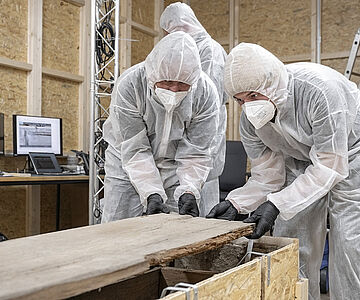 Abnehmen des hölzernen Sargdeckels