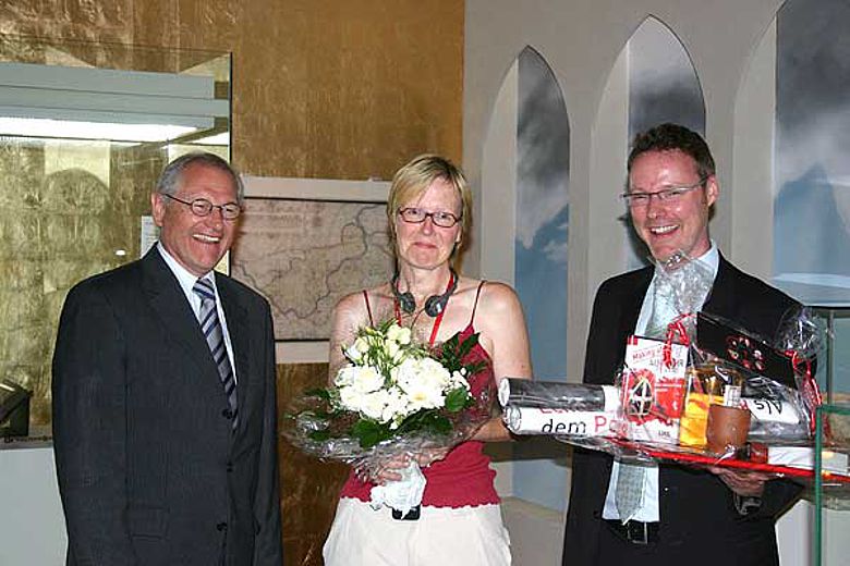 v.l.: Dr. Wolfgang Kirsch und der Museumsleiter Dr. Josef Mühlenbrock gratulieren der Jubiläumsbesucherin Katharina Huy aus Hattingen. (Foto: LWL/Jansen)