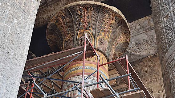 Ein bereits restauriertes Säulenkapitell zeigt die florale Verzierung in Farbe