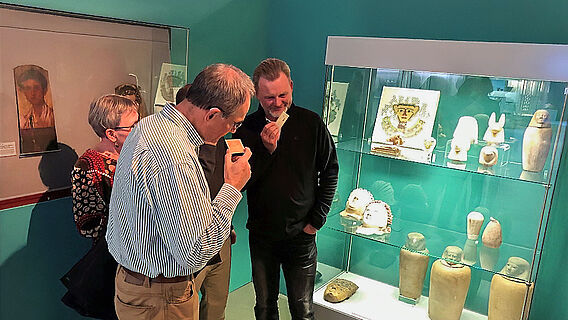 Besucherinnen und Besucher riechen an der Karte "Der Duft des Jenseits" während einer Führung im Museum August Kestner, Hannover, Deutschland