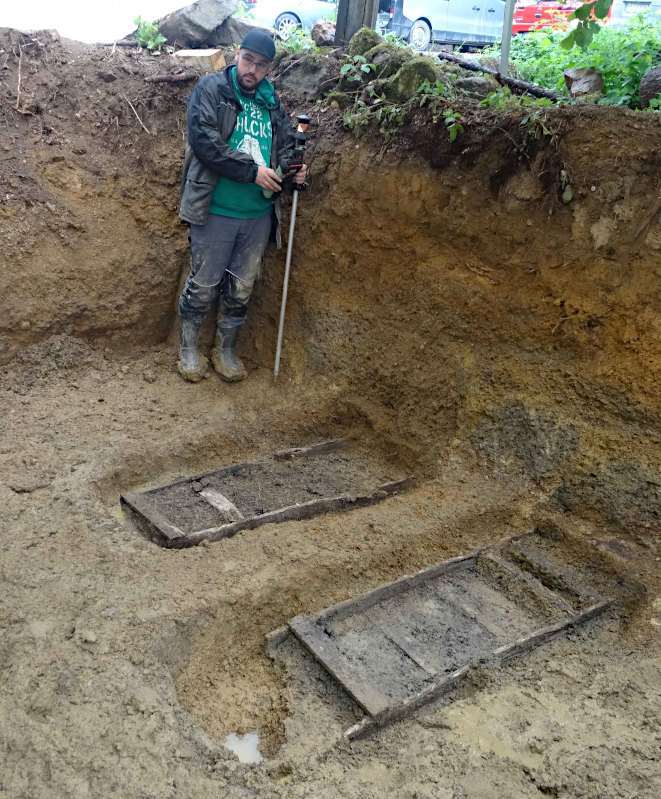Der studentische Volontär Fabian Geldsetzer dokumentiert die am Boden zweier Grabgruben erhaltenen hölzernen Tragen