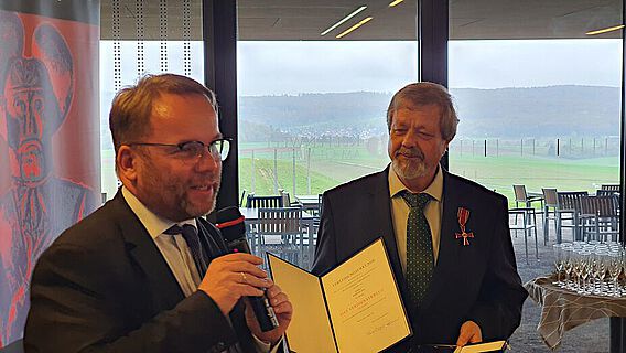 Staatsminister Timon Gremmels überreichte die Auszeichnung an Werner Erk direkt am Ort des Geschehens: in der Keltenwelt am Glauberg