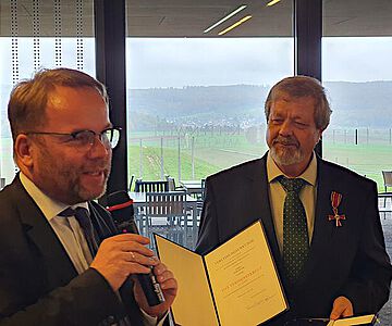 Staatsminister Timon Gremmels überreichte die Auszeichnung an Werner Erk direkt am Ort des Geschehens: in der Keltenwelt am Glauberg