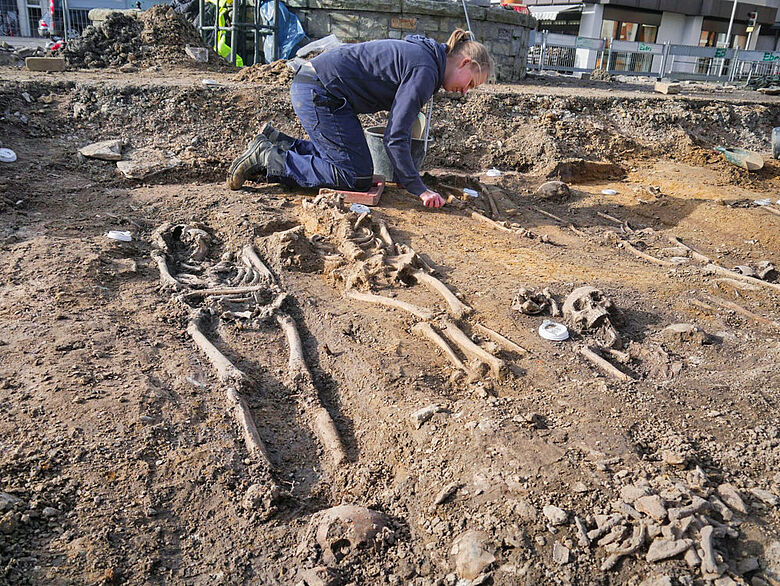 Archäologin legt Skelette frei