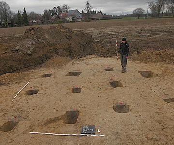 Die Pfostenlöcher zeigen einen größeren Hausgrundriss an, der zu einem Neunpfostengebäude gehörte