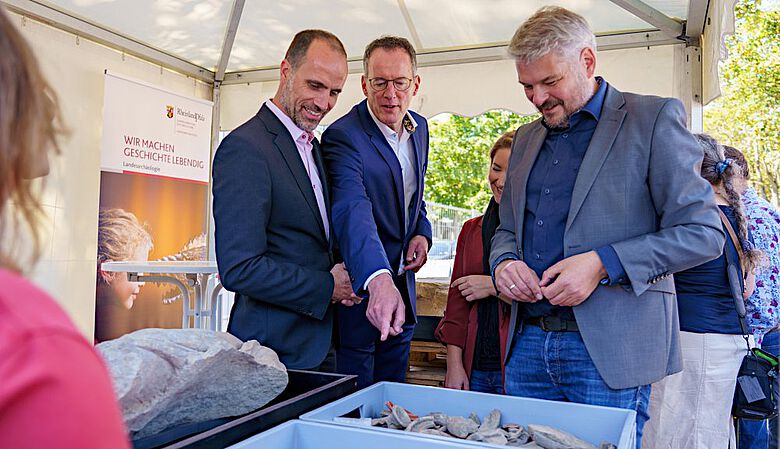 Wissenschaftsminister Clemens Hoch und Innenminister Michael Ebling mit Dr. Ulrich Himmelmann von der GDKE bei der Präsentation der Funde vom TRON-Baufeld in Mainz