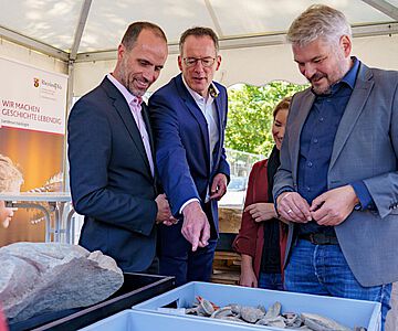 Wissenschaftsminister Clemens Hoch und Innenminister Michael Ebling mit Dr. Ulrich Himmelmann von der GDKE bei der Präsentation der Funde vom TRON-Baufeld in Mainz