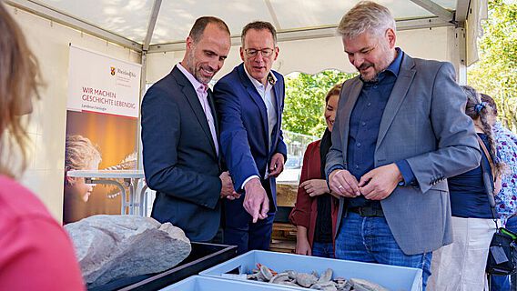 Wissenschaftsminister Clemens Hoch und Innenminister Michael Ebling mit Dr. Ulrich Himmelmann von der GDKE bei der Präsentation der Funde vom TRON-Baufeld in Mainz