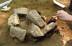 Mahlsteinfragmente und anstehender Kieselschiefer, wohl Fundament für einen Pfosten im weichen Untergrund der Fläche 33 Mahlsteinfragmente und anstehender Kieselschiefer, wohl Fundament für einen Pfosten im weichen Untergrund der Fläche 33