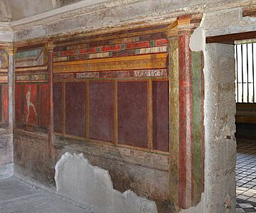In der Villa dei Misterii (Pompeji) bilden die dekorativen und figürlichen Elemente der Wand- und Bodengestaltung im Zusammenspiel mit der Architektur ein komplexes Raum-Bild-Ensemble