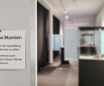 Bereich der Mumienausstellung mit Hinweisschildern auf menschliche Überreste