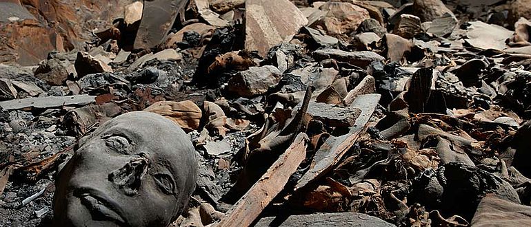 Mumifizierte Überreste zwischen Sargfragmenten, Stoffresten und Scherben