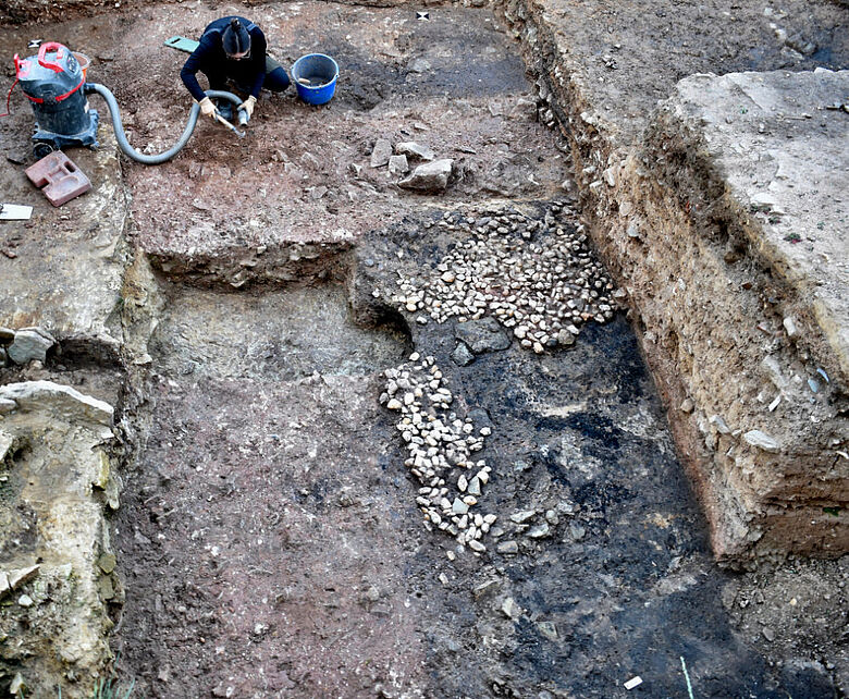 Ausbruchgrube der Südmauer und vor ihr liegender Fußbodenrest des Bischofspalasts aus der Zeit um 1000