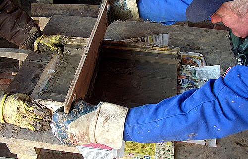 Handarbeit wie vor 2000 Jahren: Museumsmitarbeiter beim Streichen eines römischen Ziegels. (Foto: LWL/Hudemann)