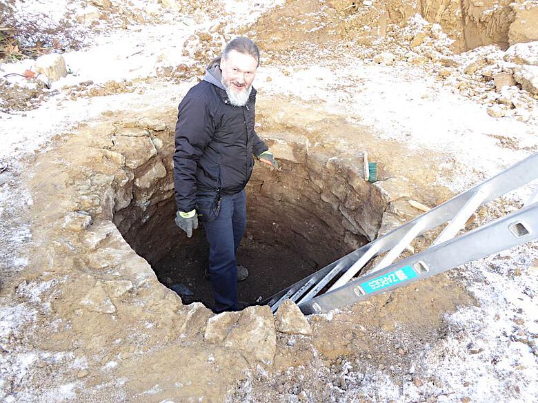 Grabungstechniker Udo Granzin legt den Brunnen im Hinterhof frei.