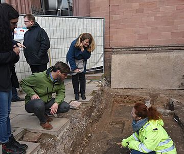 Gemeinsam mit Nunzia Macchiarella und Dagmar Kroemer (Untere Denkmalschutzbehörde) betrachten Bezirksarchäologe Peter Steffens und Grabungsleiterin Anke S. Weber (SPAU) die vorläufigen Ergebnisse