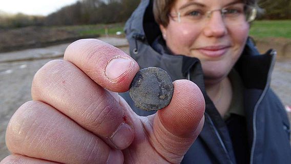 Grabungsleiterin Eva Manz präsentiert eine römische Münze
