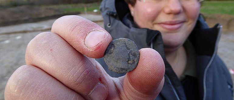 Grabungsleiterin Eva Manz präsentiert eine römische Münze