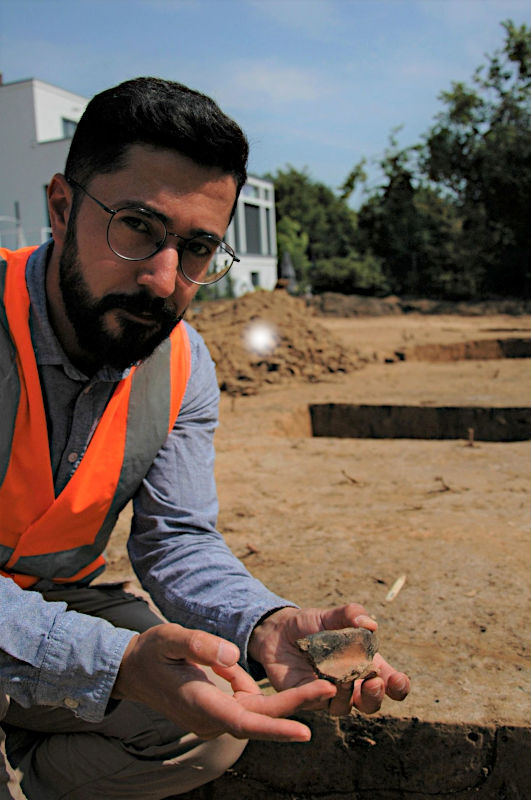 Ein unscheinbarer Fund ist ausgesprochen wichtig für die Stadtgeschichte Werthers: Grabungsleiter Hisham Nabo präsentiert die Scherbe eines Kugeltopfes, die einen Hinweis zur zeitlichen Einordnung des Gebäudes in das 10./11. Jahrhundert gibt. (Foto: LWL/S. Düvel)