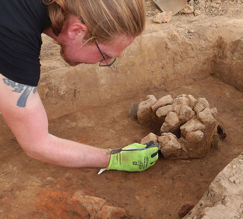 Freilegung Steinansammlung in eisenzeitlicher Grube Freilegung Steinansammlung in eisenzeitlicher Grube
