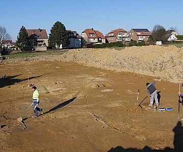 Blick über eine der Grabungsflächen: Hier sind die grauen Verfüllungen der Gruben zu erkennen