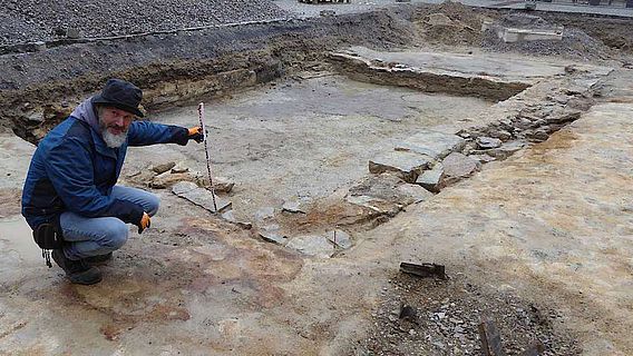Grabungstechniker Udo Granzin untersucht die Grundmauern des neu entdeckten Gebäudes