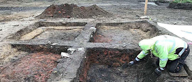 Deutlich sticht der rötlich verziegelte Lehm im einstigen Grubenhaus hervor
